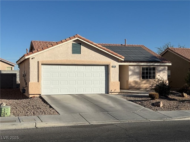 4636 Ferrell St, North Las Vegas, NV 89031 - ranch-style house featuring an attached garage, stucco siding, roof mounted solar panels, and concrete driveway
