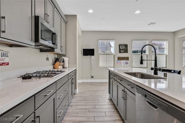 625 Honesty Ct, Henderson, NV 89011 - kitchen featuring stainless steel appliances, a sink, gray cabinets, light countertops, and plenty of natural light