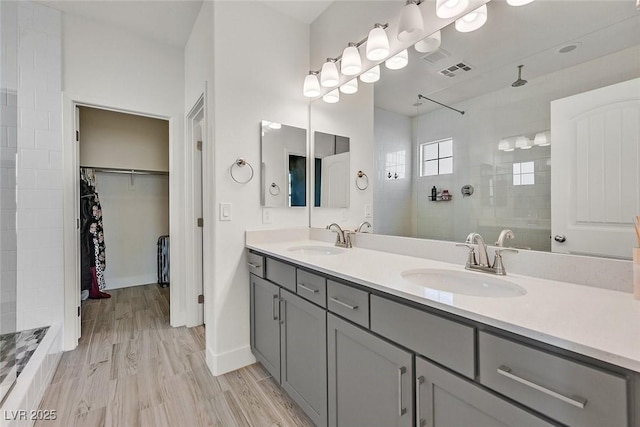 625 Honesty Ct, Henderson, NV 89011 - bathroom featuring double vanity, a walk in shower, a walk in closet, and wood finished floors
