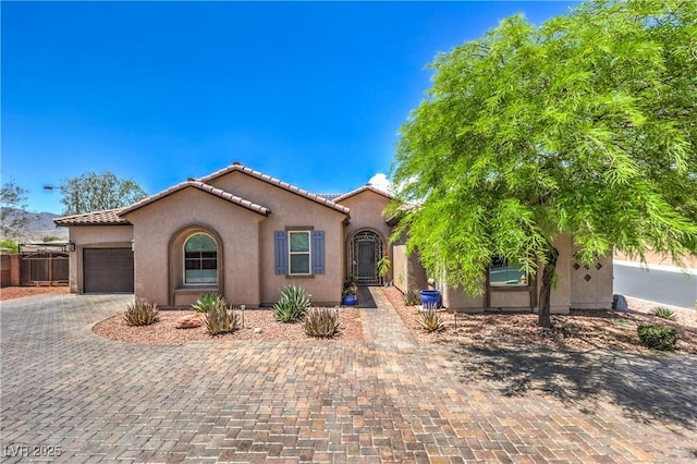 10319 Larkmead Ave, Las Vegas, NV 89149 - mediterranean / spanish house featuring stucco siding, an attached garage, a tile roof, and decorative driveway