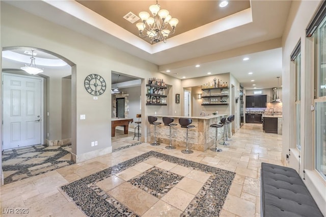 10319 Larkmead Ave, Las Vegas, NV 89149 - foyer entrance featuring stone tile floors, arched walkways, baseboards, a chandelier, and recessed lighting