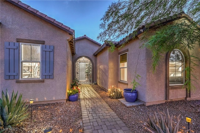 10319 Larkmead Ave, Las Vegas, NV 89149 - view of exterior entry with stucco siding, a tiled roof, and a gate