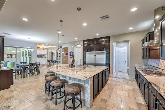 10319 Larkmead Ave, Las Vegas, NV 89149 - kitchen with stainless steel appliances, stone tile floors, light stone countertops, pendant lighting, and recessed lighting