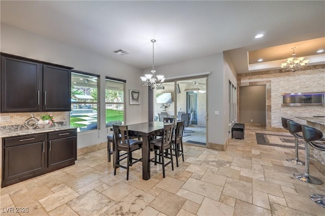 10319 Larkmead Ave, Las Vegas, NV 89149 - dining room with a chandelier, baseboards, stone tile floors, and recessed lighting