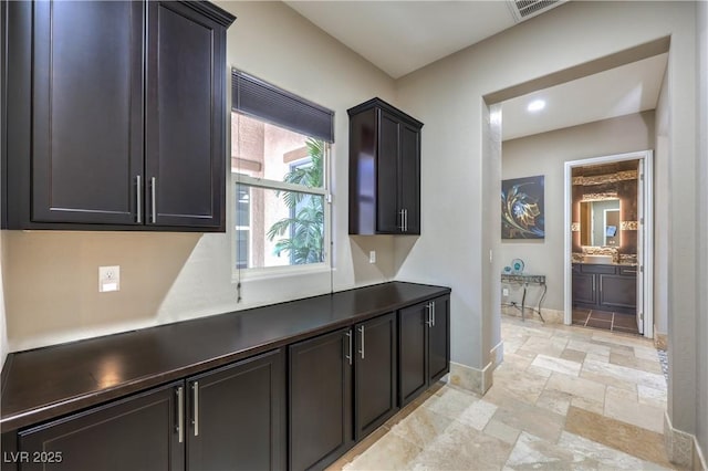 10319 Larkmead Ave, Las Vegas, NV 89149 - kitchen featuring baseboards, light stone finish flooring, and dark countertops