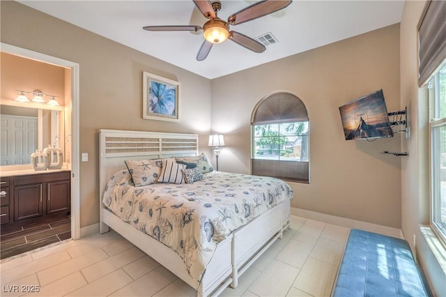 10319 Larkmead Ave, Las Vegas, NV 89149 - bedroom with multiple windows, baseboards, and connected bathroom