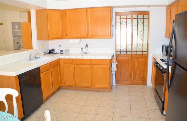 3519 W Red Coach Ave, North Las Vegas, NV 89031 - kitchen with black appliances, light countertops, light tile patterned flooring, and brown cabinetry