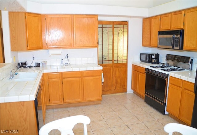 3519 W Red Coach Ave, North Las Vegas, NV 89031 - kitchen featuring stainless steel microwave, gas range, a sink, and tile counters