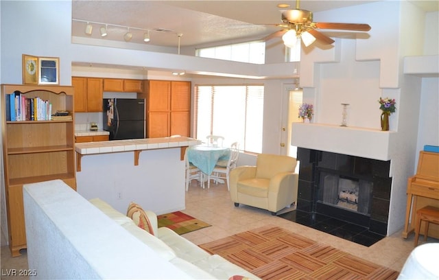 3519 W Red Coach Ave, North Las Vegas, NV 89031 - living room with light tile patterned flooring, ceiling fan, and a tile fireplace