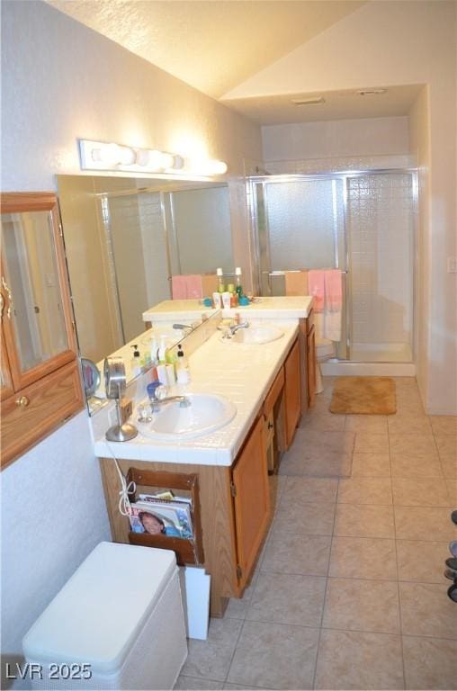 3519 W Red Coach Ave, North Las Vegas, NV 89031 - full bathroom with vaulted ceiling, tile patterned floors, a shower stall, and double vanity
