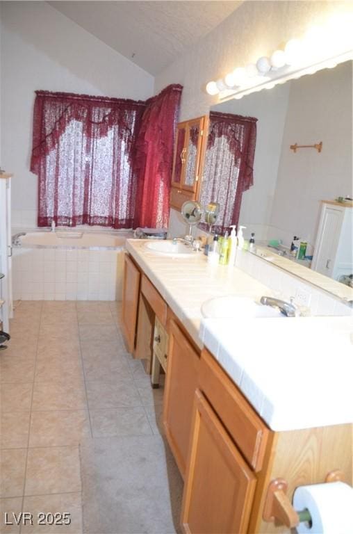 3519 W Red Coach Ave, North Las Vegas, NV 89031 - bathroom with tile patterned flooring, double vanity, tiled bath, and vaulted ceiling
