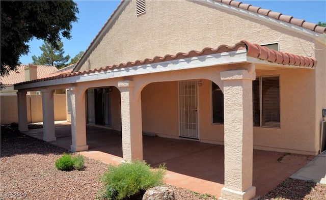 3519 W Red Coach Ave, North Las Vegas, NV 89031 - rear view of house featuring a tile roof, a patio, and stucco siding