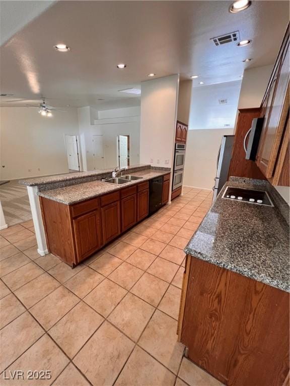 7255 W La Madre Way, Las Vegas, NV 89149 - kitchen featuring black appliances, light tile patterned floors, a peninsula, brown cabinetry, and recessed lighting