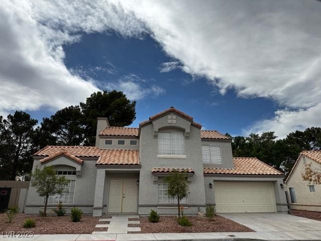 3005 Treasure Island Rd, Las Vegas, NV 89128 - mediterranean / spanish home featuring concrete driveway, a tile roof, stucco siding, and a garage