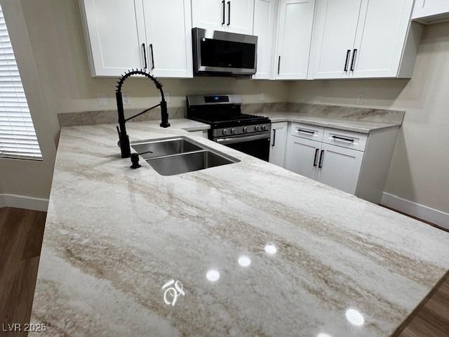 3005 Treasure Island Rd, Las Vegas, NV 89128 - kitchen featuring stainless steel appliances, baseboards, and light stone counters