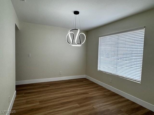3005 Treasure Island Rd, Las Vegas, NV 89128 - spare room featuring dark wood finished floors, baseboards, and a chandelier