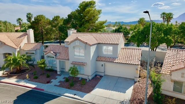 3005 Treasure Island Rd, Las Vegas, NV 89128 - mediterranean / spanish-style house with a tiled roof, concrete driveway, stucco siding, a garage, and a mountain view