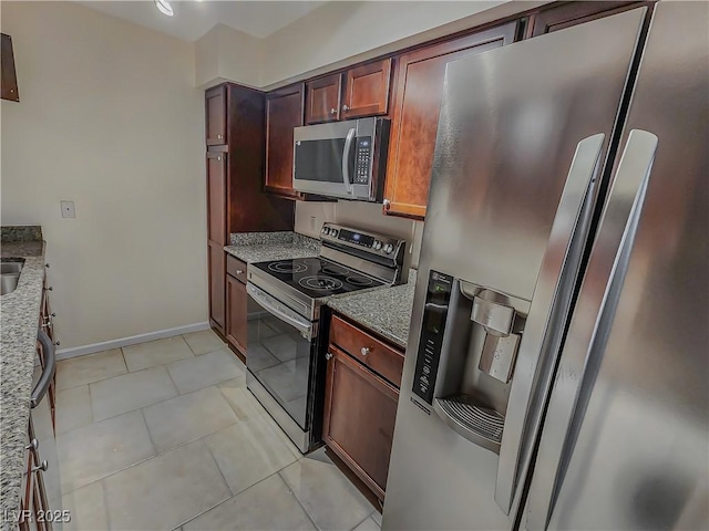 2867 Geary Pl Unit 3008, Las Vegas, NV 89109 - kitchen with appliances with stainless steel finishes, light stone countertops, light tile patterned flooring, and baseboards