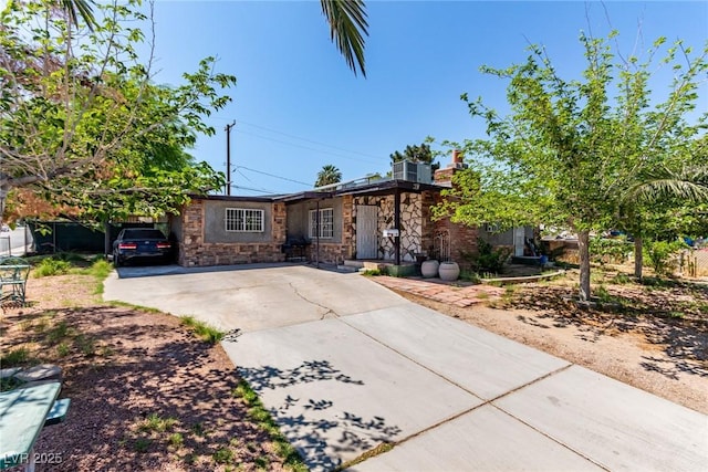 201 Cervantes St, Las Vegas, NV 89101 - view of front of home with concrete driveway, stone siding, and a chimney