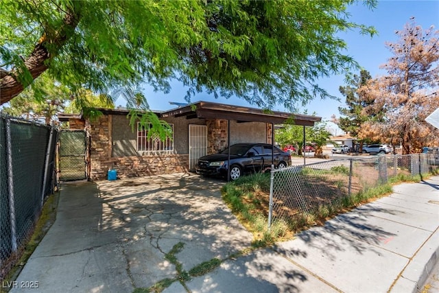 201 Cervantes St, Las Vegas, NV 89101 - view of front facade featuring stone siding, concrete driveway, a gate, and an attached carport