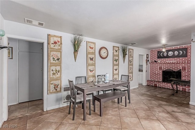 201 Cervantes St, Las Vegas, NV 89101 - dining room with a fireplace, radiator heating unit, and light tile patterned floors