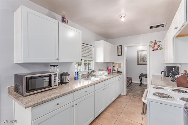 201 Cervantes St, Las Vegas, NV 89101 - kitchen featuring a sink, stainless steel microwave, white electric range oven, white cabinetry, and light countertops