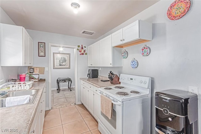 201 Cervantes St, Las Vegas, NV 89101 - kitchen featuring white range with electric stovetop, a sink, light countertops, white cabinets, and light tile patterned flooring