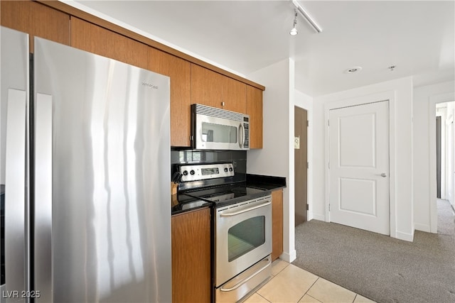 29 Montelago Blvd Unit 520, Henderson, NV 89011 - kitchen featuring appliances with stainless steel finishes, brown cabinets, light colored carpet, and dark countertops