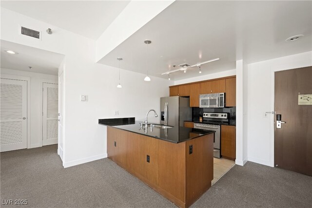 29 Montelago Blvd Unit 520, Henderson, NV 89011 - kitchen with appliances with stainless steel finishes, a peninsula, dark countertops, brown cabinetry, and a sink