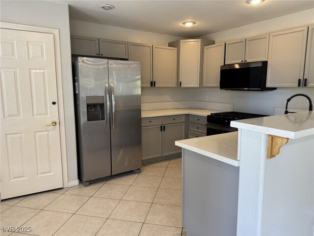 11029 Meadow Leaf Ave, Las Vegas, NV 89144 - kitchen with black appliances, gray cabinets, a peninsula, light countertops, and light tile patterned floors