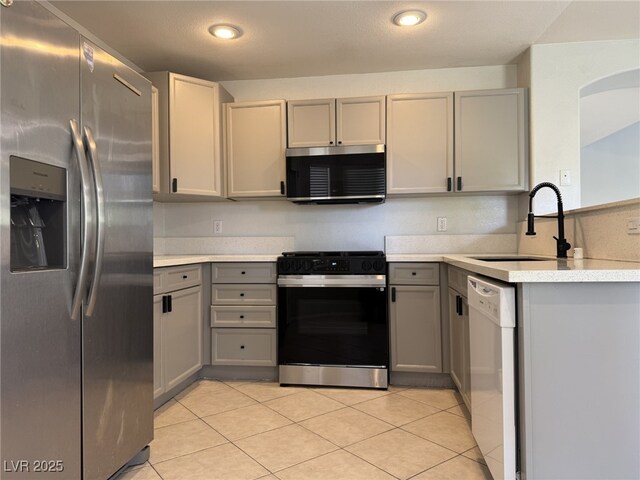 11029 Meadow Leaf Ave, Las Vegas, NV 89144 - kitchen with appliances with stainless steel finishes, gray cabinets, a sink, light countertops, and light tile patterned floors