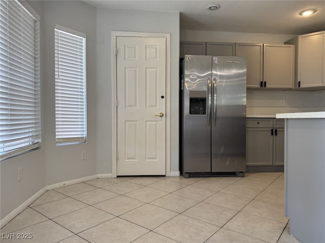 11029 Meadow Leaf Ave, Las Vegas, NV 89144 - kitchen with stainless steel refrigerator with ice dispenser, gray cabinetry, light countertops, light tile patterned floors, and baseboards