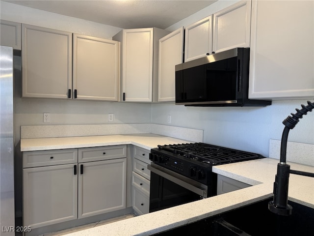 11029 Meadow Leaf Ave, Las Vegas, NV 89144 - kitchen featuring black range with gas cooktop, gray cabinets, and light stone countertops