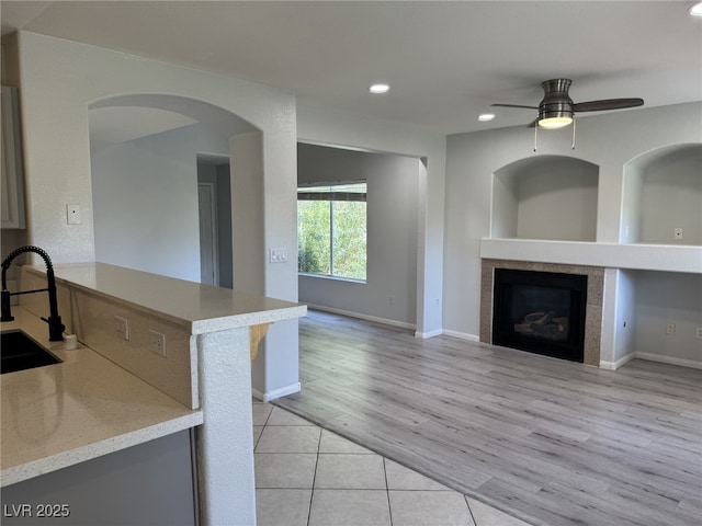 11029 Meadow Leaf Ave, Las Vegas, NV 89144 - kitchen with a sink, a ceiling fan, recessed lighting, a tile fireplace, and light wood finished floors