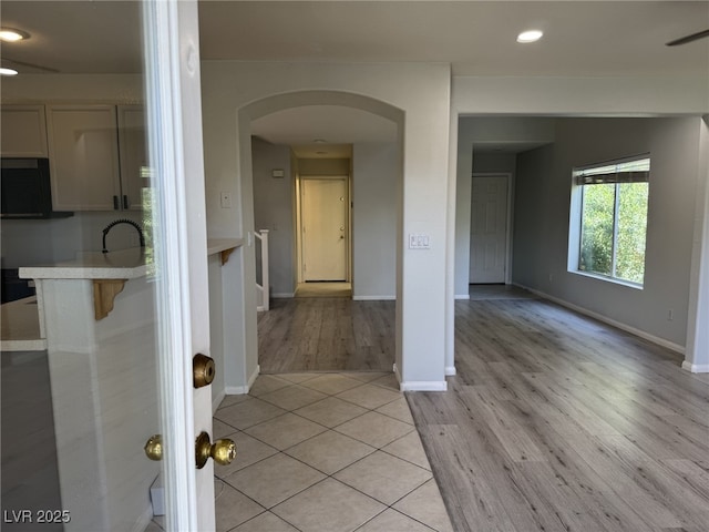 11029 Meadow Leaf Ave, Las Vegas, NV 89144 - kitchen with arched walkways, light countertops, light wood finished floors, a ceiling fan, and recessed lighting
