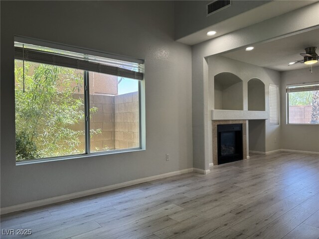 11029 Meadow Leaf Ave, Las Vegas, NV 89144 - unfurnished living room with wood finished floors, a tile fireplace, baseboards, and a ceiling fan