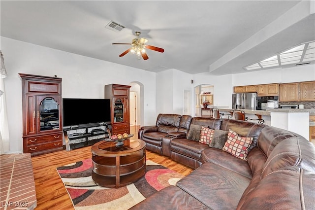 7461 Tahoe Basin Dr, Las Vegas, NV 89129 - living room with arched walkways, ceiling fan, and light wood finished floors