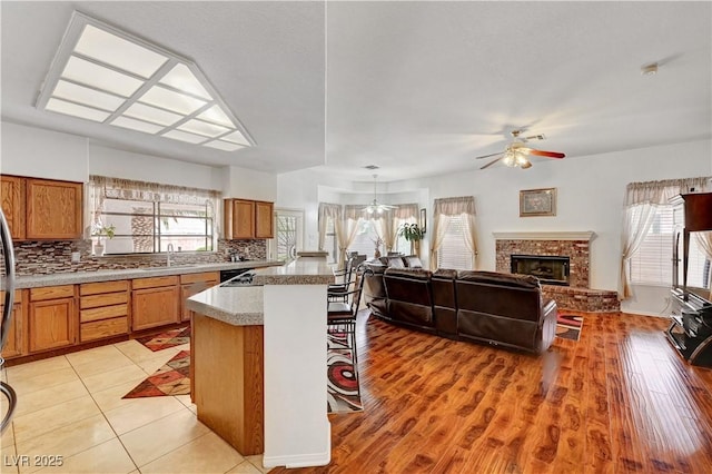 7461 Tahoe Basin Dr, Las Vegas, NV 89129 - kitchen featuring brown cabinetry, ceiling fan, backsplash, and open floor plan
