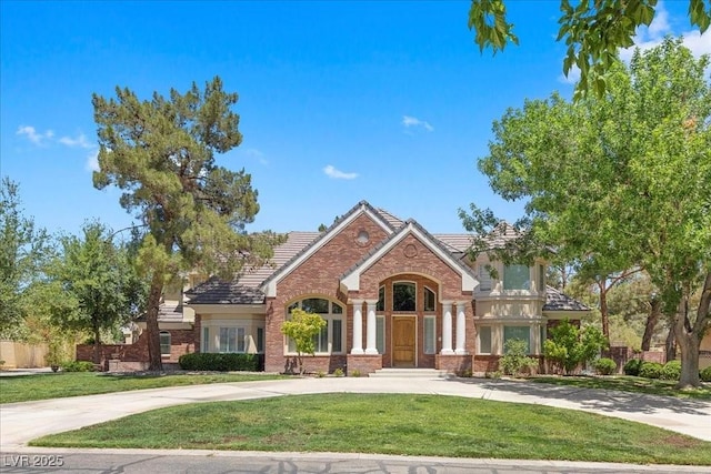 3102 La Mirada Ave, Las Vegas, NV 89120 - view of front of house with a front lawn, a tile roof, brick siding, and concrete driveway