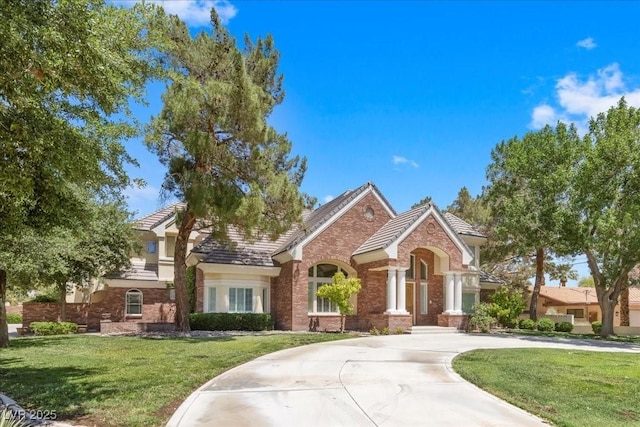3102 La Mirada Ave, Las Vegas, NV 89120 - view of front of property featuring a front yard, a tiled roof, brick siding, and curved driveway