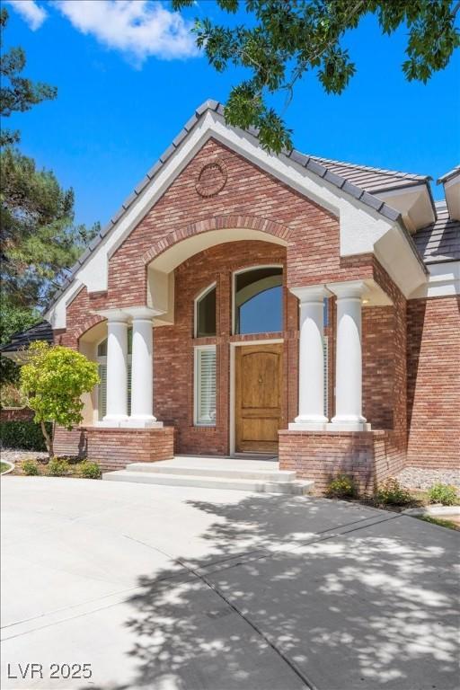 3102 La Mirada Ave, Las Vegas, NV 89120 - view of exterior entry with brick siding and a tile roof