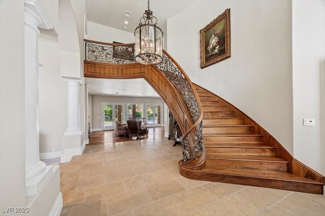 3102 La Mirada Ave, Las Vegas, NV 89120 - stairway featuring stone tile flooring, decorative columns, a towering ceiling, a chandelier, and arched walkways