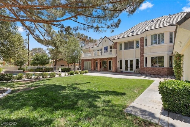 3102 La Mirada Ave, Las Vegas, NV 89120 - back of property featuring brick siding, a lawn, french doors, a tiled roof, and a balcony
