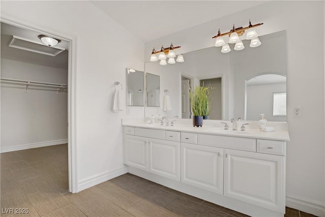 236 Dog Leg Dr, Las Vegas, NV 89148 - bathroom featuring double vanity, baseboards, and a walk in closet