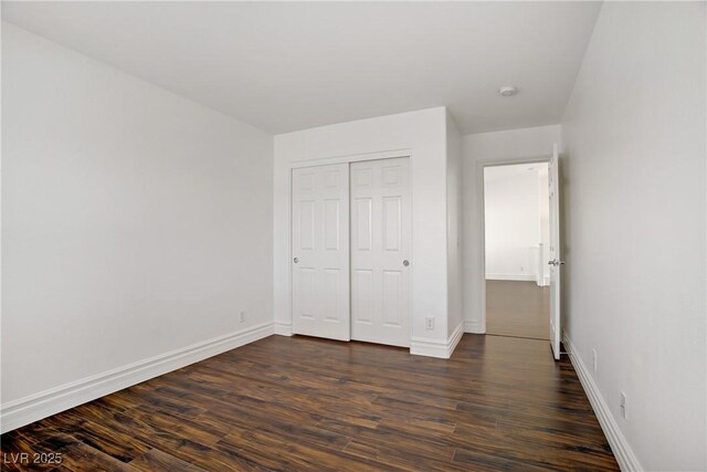 236 Dog Leg Dr, Las Vegas, NV 89148 - unfurnished bedroom featuring baseboards, dark wood-style floors, and a closet