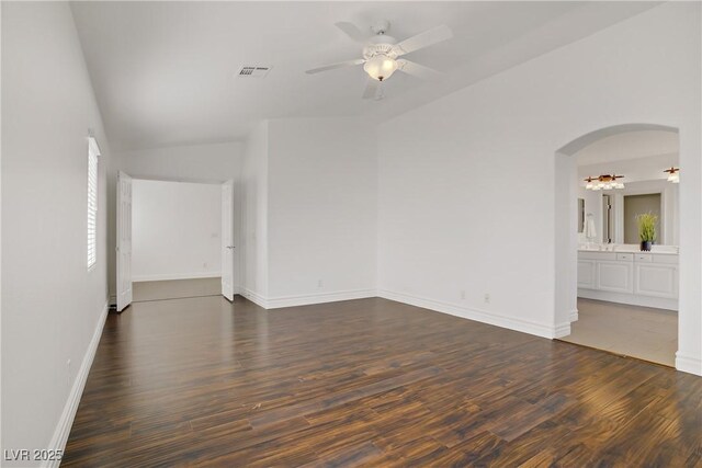 236 Dog Leg Dr, Las Vegas, NV 89148 - unfurnished room featuring a ceiling fan, dark wood finished floors, arched walkways, baseboards, and vaulted ceiling
