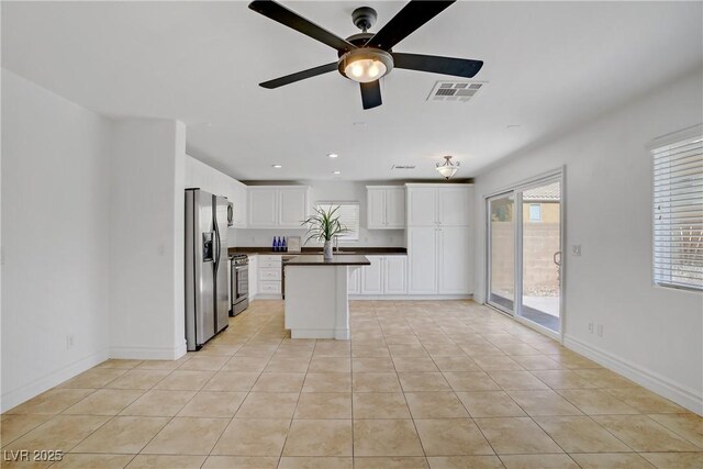 236 Dog Leg Dr, Las Vegas, NV 89148 - kitchen with stainless steel appliances, dark countertops, a ceiling fan, light tile patterned floors, and recessed lighting