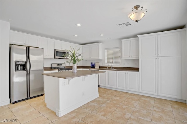 236 Dog Leg Dr, Las Vegas, NV 89148 - kitchen featuring appliances with stainless steel finishes, a sink, white cabinetry, a center island, and light tile patterned floors