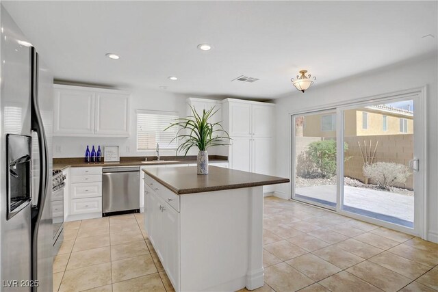 236 Dog Leg Dr, Las Vegas, NV 89148 - kitchen with appliances with stainless steel finishes, dark countertops, light tile patterned floors, plenty of natural light, and recessed lighting