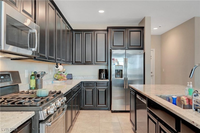 6334 Orions Belt Peak St, North Las Vegas, NV 89031 - kitchen with stainless steel appliances, a sink, light stone countertops, light tile patterned floors, and recessed lighting